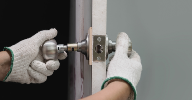 Technician installing a door lock and handle on an exterior door